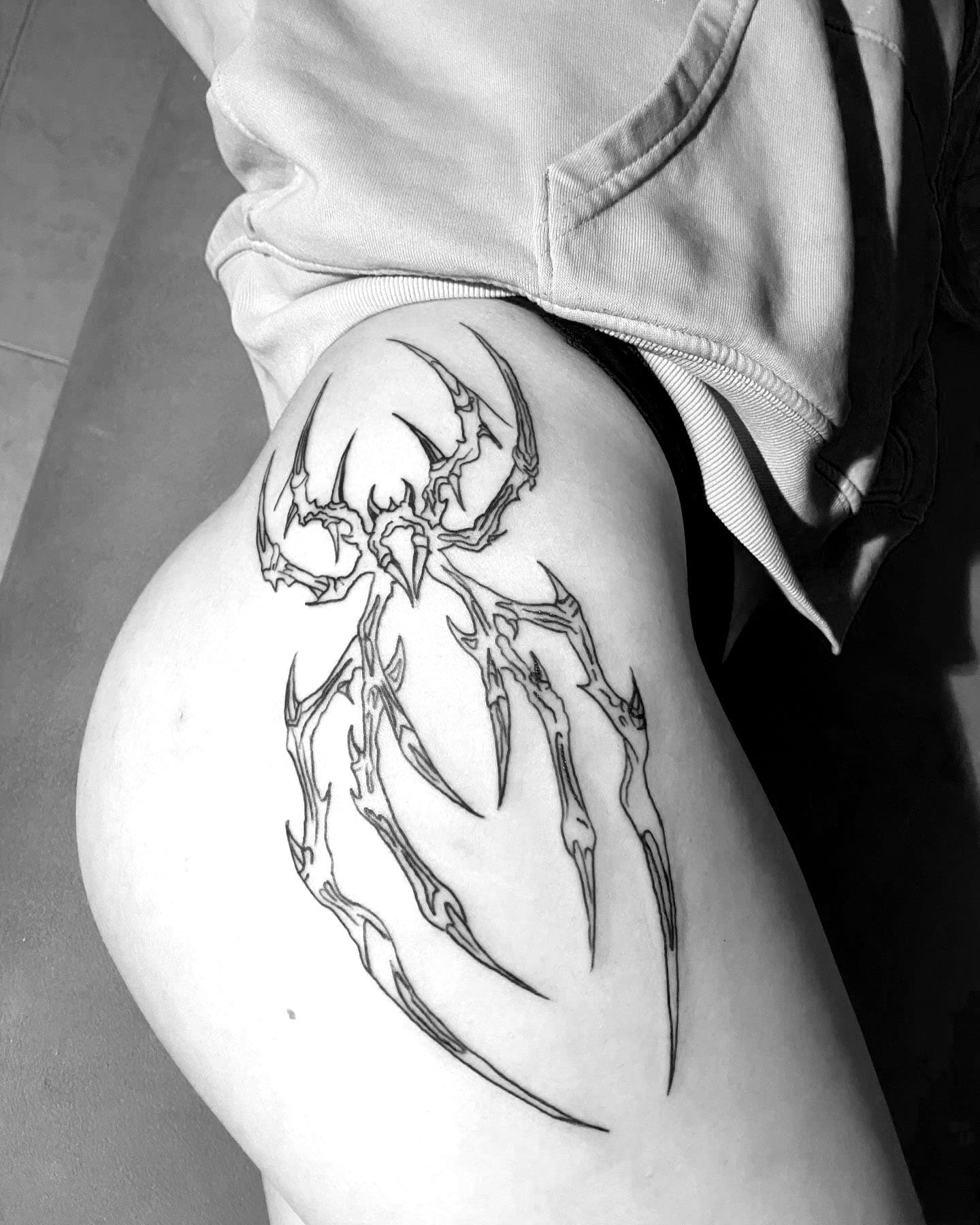 Tatuaje de araña con estilo neotribal en la pierna