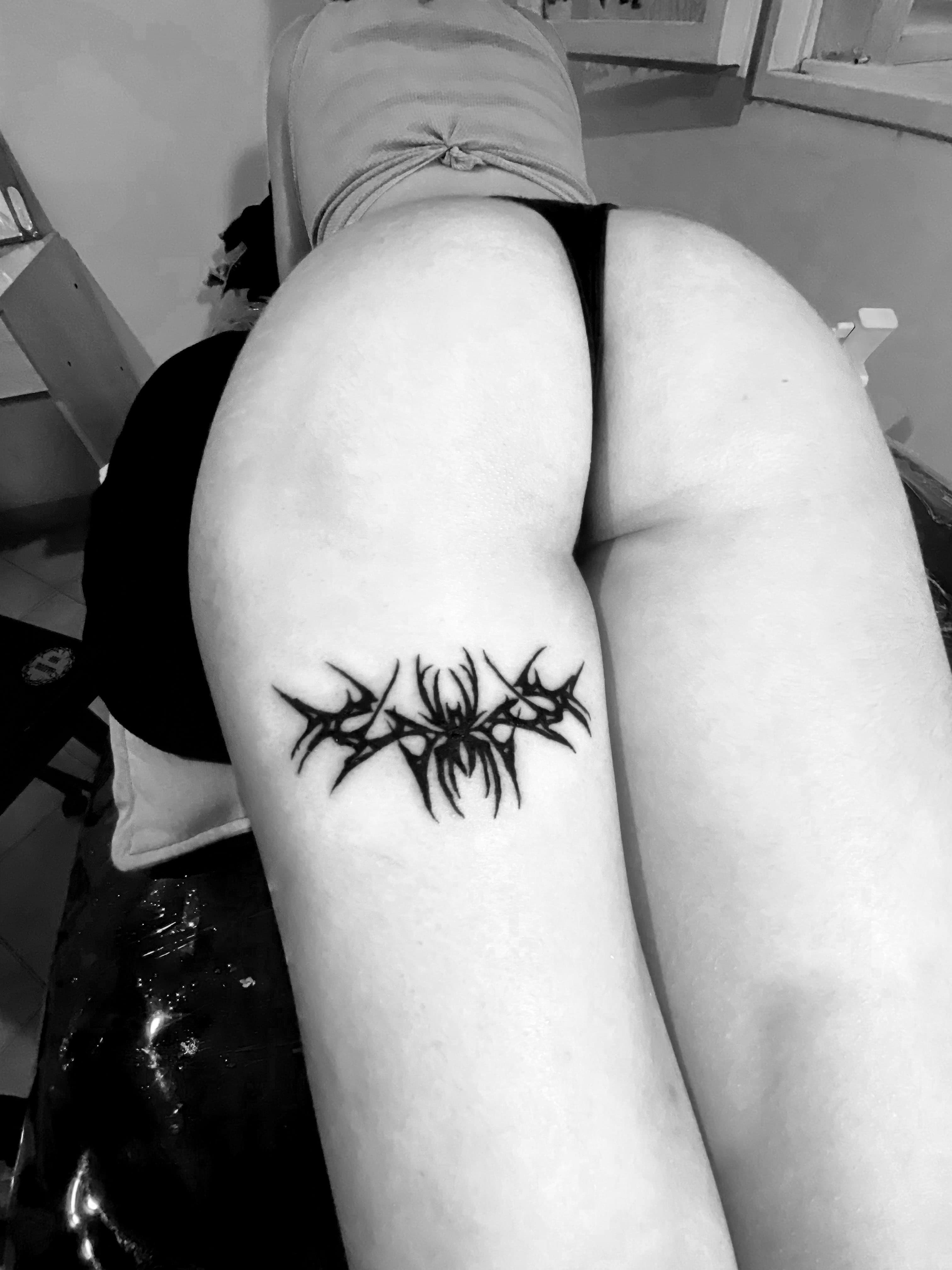 Tatuaje de araña con estilo neotribal en una pierna