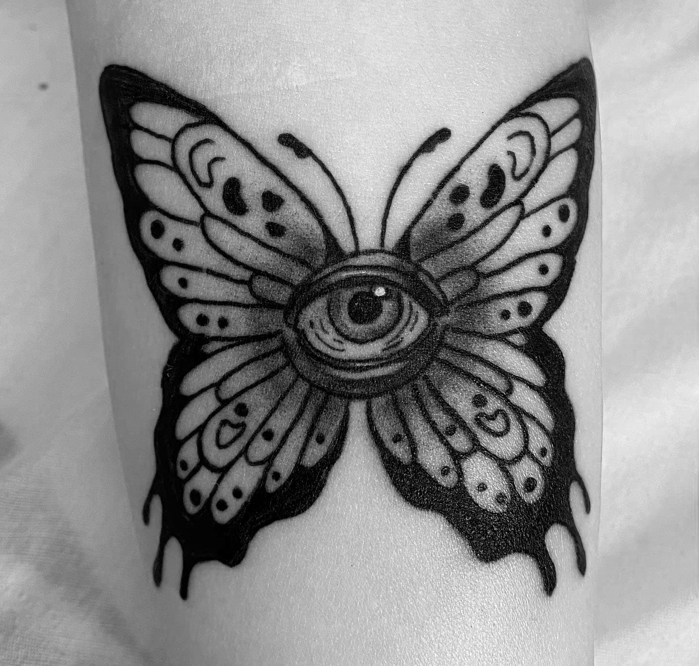 Tatuaje de mariposa con estilo Black and Grey en el brazo